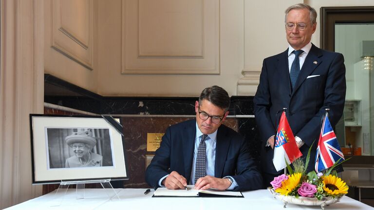 Ministerpräsident Boris Rhein und der britische Honorarkonsul Dr. Andreas Fabritius tragen sich in das Kondolenzbuch ein, das in der Hessischen Staatskanzlei ausliegt. 