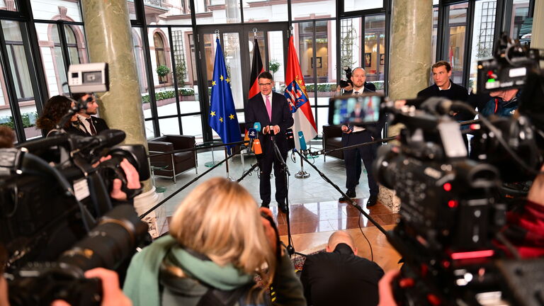 Ministerpräsident Rhein bei seinem Pressestatement nach seiner Wiederwahl, umringt von unter anderem Mikrofonen und Kameras