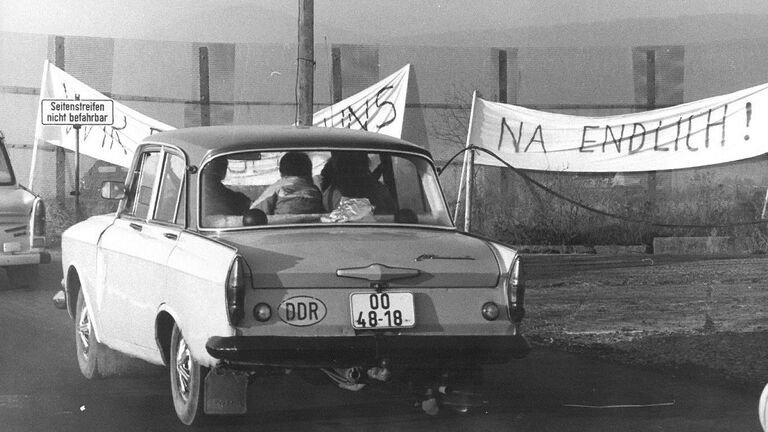 Das Bild zeigt die Grenzöffnung auf der B 84 zwischen dem thüringischen Buttlar und dem hessischen Rasdorf am 18. November 1989 um 6 Uhr. Ein Fahrzeug aus dem Kreis Schmalkalden wird gleich die innerdeutsche Grenze passieren.
