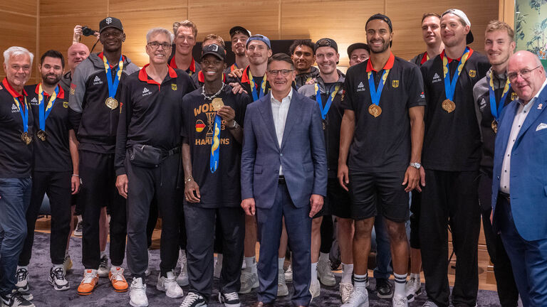 Ministerpräsident Boris Rhein gemeinsam mit der deutschen Basketball-Nationalmannschaft am Frankfurter Flughafen, alle gemeinsam zum Grupopenbild aufgestellt.