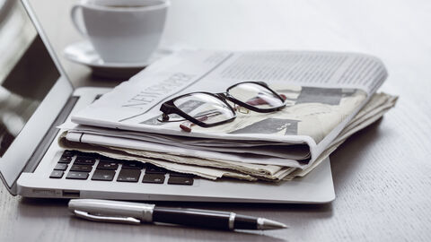 Zeitung und Brille liegen auf Laptop Zeitung und Brille liegen auf Laptop