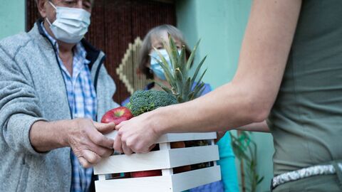 Eine Kiste mit Obst und Gemüse wird übergeben Eine Kiste mit Obst und Gemüse wird übergeben