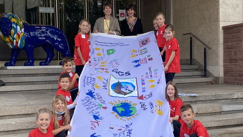 Schülerinnen und Schüler der Gönser Grundschule aus Butzbach übergeben die von ihnen gestaltete Fahne zum Thema Kinderrechte an die hessische Staatssekretärin für Soziales und Integration Anne Janz und die hessische Kinder- und Jugendrechtebeauftragte Miriam Zeleke Schülerinnen und Schüler der Gönser Grundschule aus Butzbach übergeben die von ihnen gestaltete Fahne zum Thema Kinderrechte an die hessische Staatssekretärin für Soziales und Integration Anne Janz und die hessische Kinder- und Jugendrechtebeauftragte Miriam Zeleke