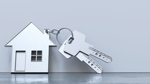 Ein silberner Schlüssel mit kleinem Häuschen-Anhänger