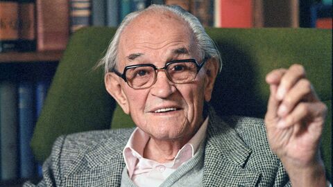 Martin Niemöller Portrait von Martin Niemöller in Sessel vor Bücherwand.