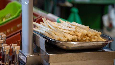 Spargel Frischer Spargel liegt auf einer Metallwaage und wird eingewogen.
