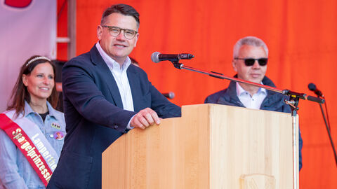 Spargelwanderung Bürstadt Lampertheim Ministerpräsident Rhein am Rednerpult bei der Spargelwanderung, hinter ihm die Lampertheimer Spargelprinzessin.