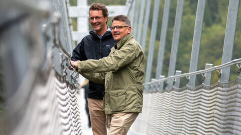 Hessens Ministerpräsident Boris Rhein und Nordrhein-Westfalens Ministerpräsident Hendrik Wüst wanderten gemeinsam vom nordhessischen Willingen ins südwestfälische Winterberg und besuchten dabei in der Nähe von Willingen die längste Hängebrücke Deutschlands, den „Skywalk“. Hessens Ministerpräsident Boris Rhein (vorne) und Nordrhein-Westfalens Ministerpräsident Hendrik Wüst (hinten) in der Nähe von Willingen auf der längsten Hängebrücke Deutschlands, dem „Skywalk“