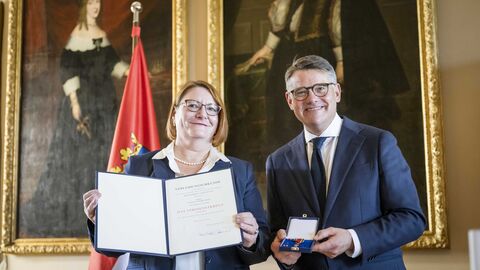 Ministerpräsident Boris Rhein mit Annette Ruske-Wolf bei der Auszeichnung. Ministerpräsident Boris Rhein überreicht Annette Ruske-Wolf das Verdienstkreuz am Bande.