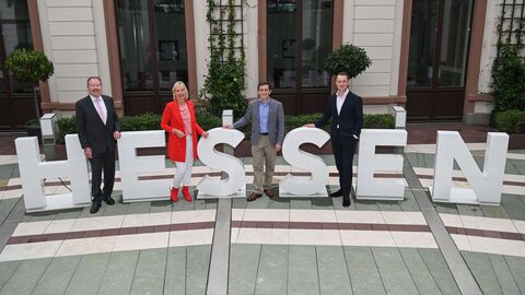 Treffen Ausbau Rechenzentren  Eine Frau und zwei Männer stehen zwischen Buchstaben, die das Wort "Hessen" ergeben.