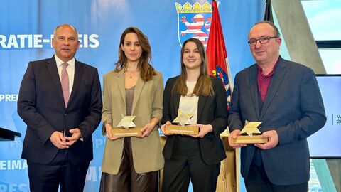Walter-Lübcke-Demokratie-Preis 2024 Innenminister Poseck steht mit den Preisträgern zum Gruppenfoto aufgestellt. Sie halten ihre Auszeichnungen in Händen.