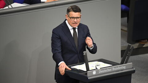 Ministerpräsident Rhein im Bundestag Ministerpräsident Rhein steht am Rednerpult des Bundestags und hält seine Rede.