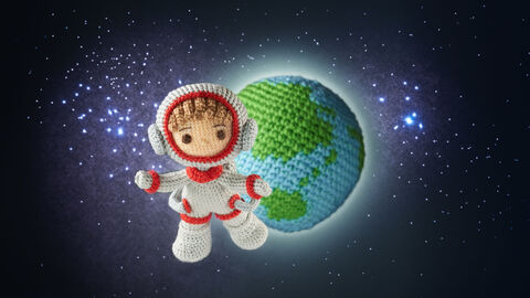 Von "Hessen in Space" zu "Häkel in Space" Ein gehäkelte Astronautenfigur vor einer gehäkelten Erde fliegt im Weltraum