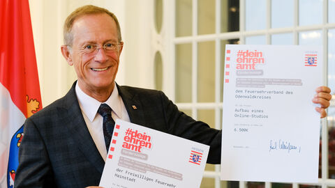 Staatsminister Axel Wintermeyer mit zwei Förderbescheiden