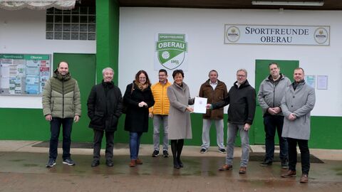 Europaministerin Lucia Puttrich bei der Übergabe des Bescheides an den 1. Vorsitzenden der Sportfreunde Oberau 1951 e.V., Herrn Thomas Haas, und weiteren Mitgliedern des Sportvereins.