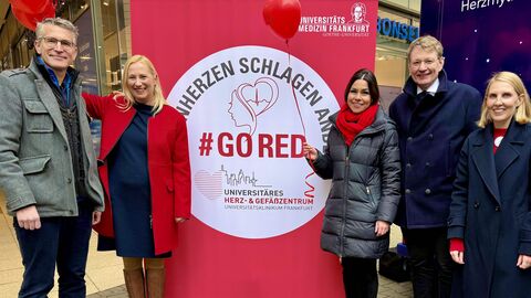 Fünf Personen stehen vor einem roten Plakataufsteller mit der Aufschrift "GoRed"