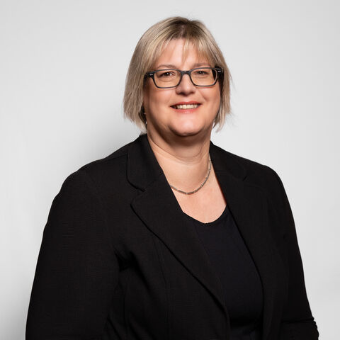 Dr. Sonja Optendrenk vor grauem Hintergrund